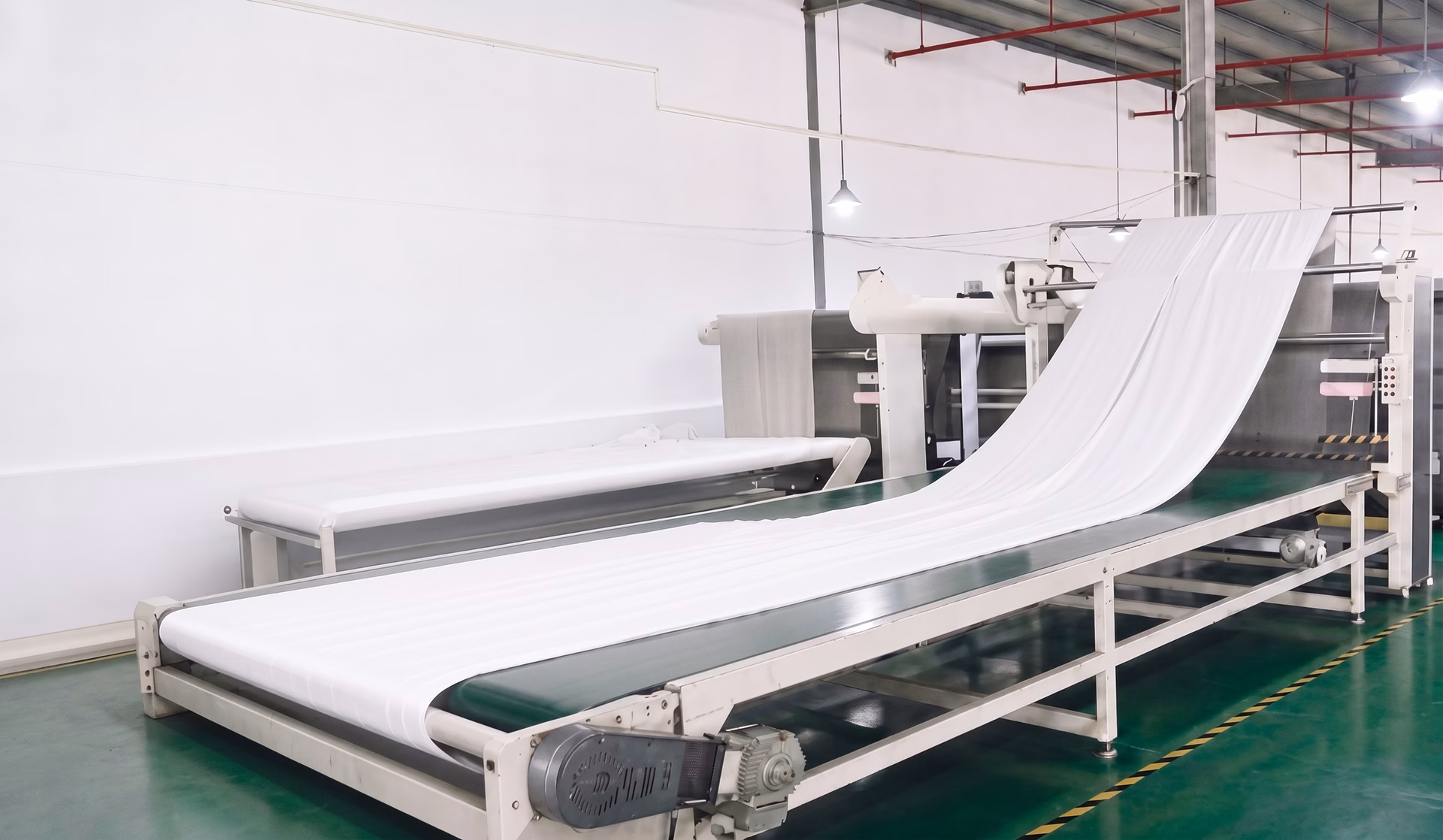 Textile manufacturing machine processing white fleece blanket